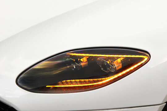 Car headlights. Luxury Headlights. Part of the white car. The headlights are on
