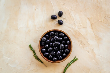 Wooden bowl of pickled black olives, top view