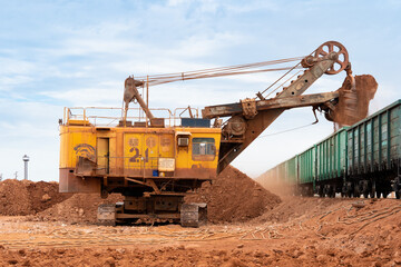 large excavator loads rock with iron or bauxite mining