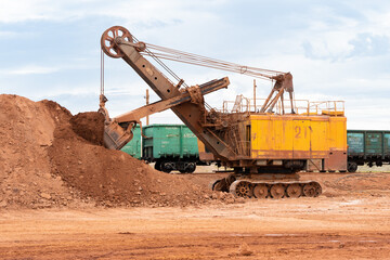 large excavator loads rock with iron or bauxite mining