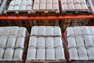 Rows of packed plastic cisterns with liquid goods in storage room