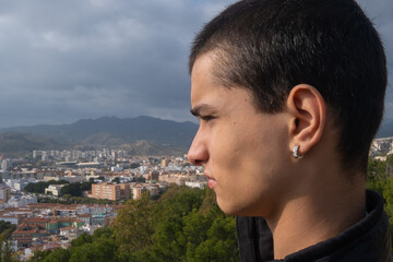 Young boy looking sideways at Malaga city in Spain.