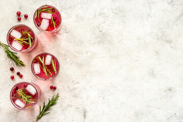 Obraz na płótnie Canvas Glasses of cranberry lemonade and red oranges with rosemary