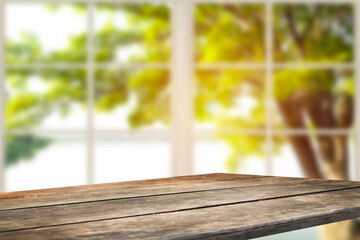 photo montage of a wooden table with a white window and a view of a green landscape