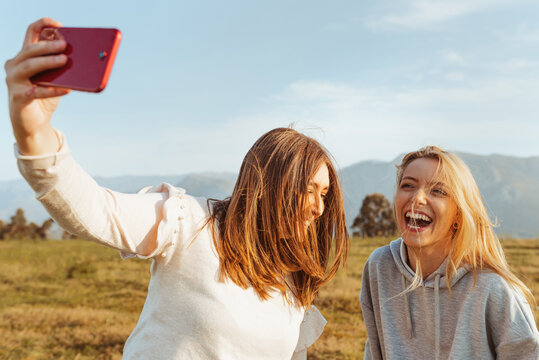Cheerful woman taking selfie with smartphone