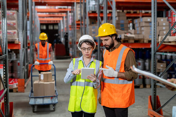 Two workers in hardhats scrolling through data in tablet