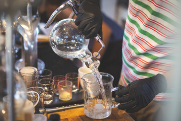 Select the focus glass container after distillation people pouring liquor Liquid in a glass jar in a lab Production and distillation