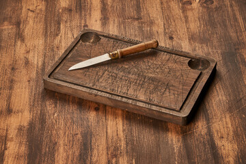 Cutting board with knife on wooden table