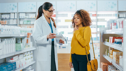 Pharmacy: Professional Caucasian Pharmacist Helping Beautiful Black Female Customer with Medicine Recommendation, Advice, Talking. Drugstore with Full of Drugs, Pills, Health Care, Beauty Products