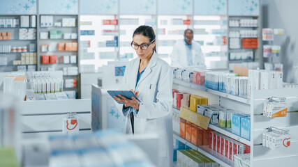 Pharmacy Drugstore: Beautiful Caucasian Pharmacist Uses Digital Tablet Computer, Checks Inventory...