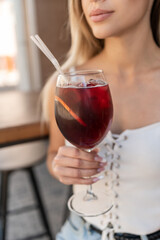 female holding iced and fresh summer cocktail with vermouth and gin