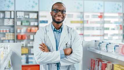 Pharmacy: Professional Confident Black Pharmacist Wearing Lab Coat and Glasses, Crosses Arms and...