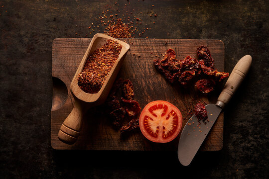 Fresh and dried tomato on wooden board