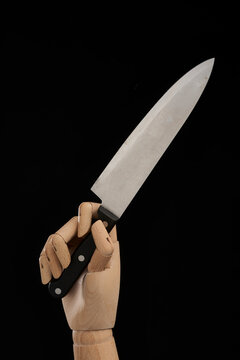 Crop wooden hand with sharp knife in studio