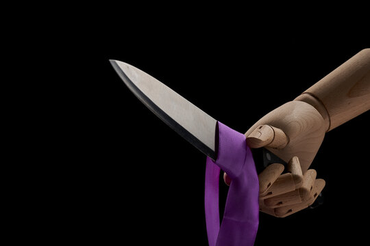Crop wooden hand with sharp knife in studio