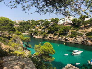 Fototapeta premium Cala Pi bay in the southern part of Mallorca with crystal clear turquoise water and yachts from above