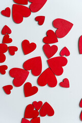 hand painted wooden shapes (hearts) in cadmium deep red acrylic paint on a light background - photographed from above with ambient light