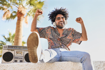 African american man listening music from vintage boombox outdoor - Young mixed race person and retro concept