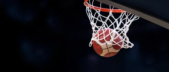 Fotobehang The orange basketball ball flies through the basket. Professional sport concept.. © Augustas Cetkauskas