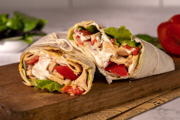 Homemade shawarma or burrito or chicken roll with vegetables and sauce