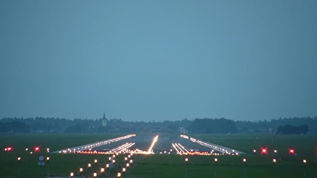 Empty runway, Ljubljana airport, Slovenia. Aircraft landing. View of long runway spectacularly lit with countless number of colorful lights. Static shot, real time