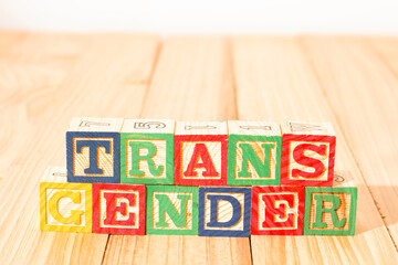 Spectacular wooden cubes with the word TRANSGENDER on a wooden surface.