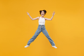 Fototapeta na wymiar Full length young successful fun overjoyed happy woman 20s with bob haircut wearing white tank top shirt jumping high with outstretched hands isolated on yellow background People lifestyle concept