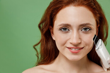 Beautiful close up half naked topless redhead hair woman 20s with nude make up hold ultrasonic face...