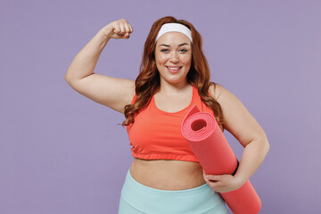 Young fun chubby overweight plus size big fat fit woman wear red top warm up training hold yoga mat show biceps muscles isolated on purple background studio home gym. Workout sport motivation concept.