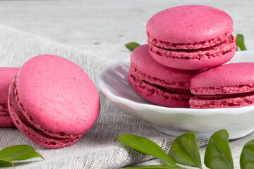Pink macaroons in a white bowl.