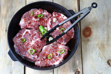 Raw steaks with spices in a cast iron grill pan. Cooking steaks.