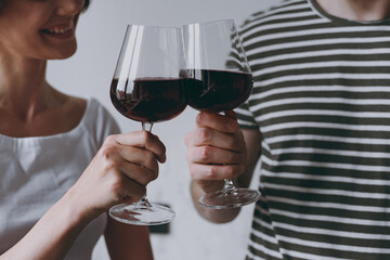 Close up croped up photo shot young smiling couple two woman man in casual striped t-shirt clothes drink red wine celebrate anniversary new dwelling at home together People leisure lifestyle concept.
