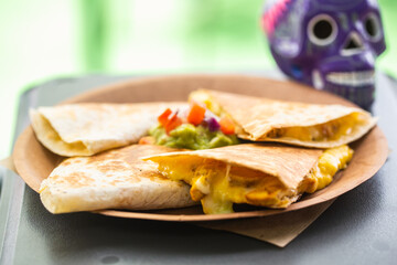 Quesadilla with meat and cheese on top of which salsa on a paper plate