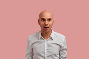 Can not be. Excited interested bald guy with bristle, keeps mouth opened, reacts on shocking news...