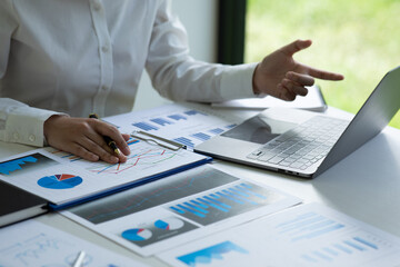 Financial Businesswomen analyze the graph of the company's performance to create profits and...