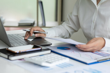 Financial Businesswomen analyze the graph of the company's performance to create profits and growth, Market research reports and income statistics, Financial and Accounting concept.