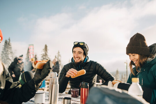 Tre leende v&auml;nner &auml;ter lunch tillsammans utomhus