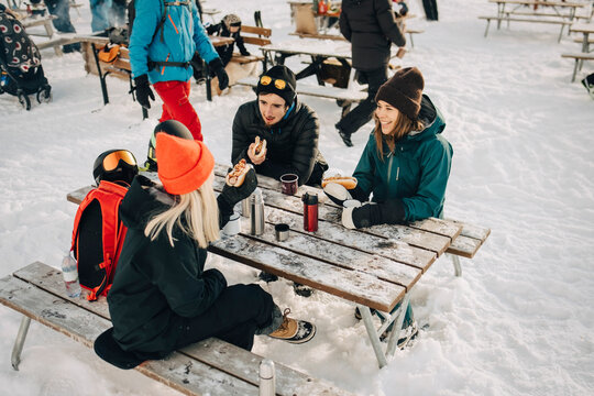 V&auml;nner &auml;ter lunch och diskuterar utomhus under vinterdag