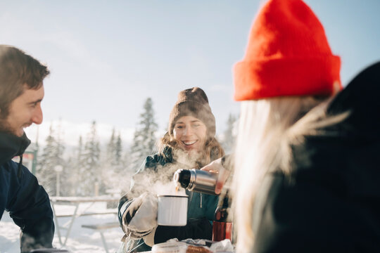 Kvinna h&auml;ller upp kaffe ur termos till v&auml;n