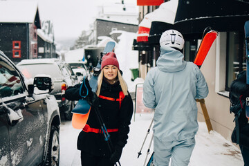 Ung kvinna går med skidor på gata i skidort
