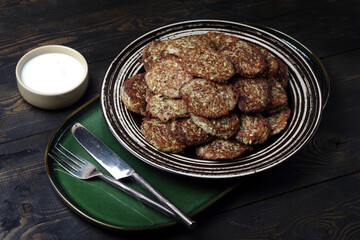 Homemade vegetarian zucchini and mushrooms pancakes served with unsweetened yogurt