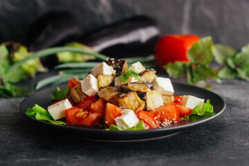 Salad with eggplants, tomatoes and feta cheese. Delicious salad on a plate