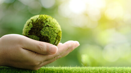 Close up of hands holding the earth on a green background. protect nature. Save Earth. concept of the environment World Earth Day