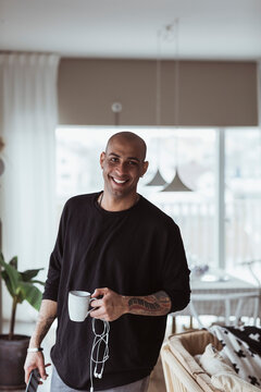 Portr&auml;tt av leende man med kaffekopp i handen