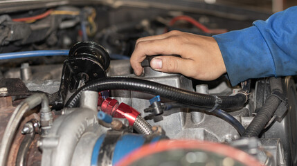 The mechanic is checking the engine.