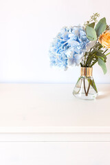 Bouquet with Blue Hydrangea flower and roses in the glass vase. Floral composition	