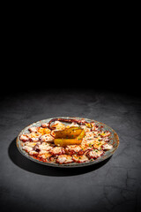 Dark food photography of sliced octopus beautiful decorated. Moody image of modern version of a modern cuisine of a typical spanish tapas meal.