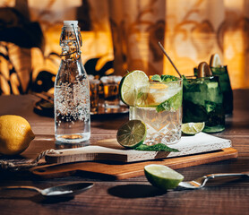 Dark photography of a cold drink, a glass of mojito with mint leaf, ice, lemon and sugar on a...