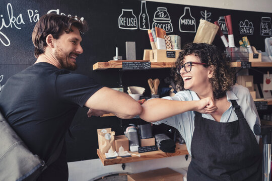 Leende &auml;gare h&auml;lsar p&aring; kund i ekologisk matbutik