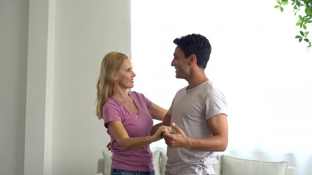 Lovers In A Living Room. Happy Middle Age Senior Couple Enjoying Dancing With Husband At Home. Cheerful Middle Family Feeling Excited Spending Time Together In Cozy Modern Living Room.